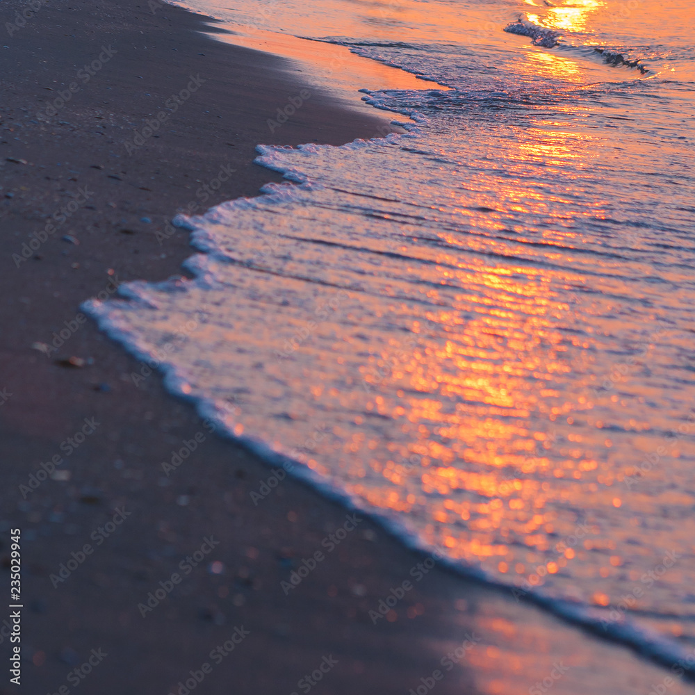 Φωτογραφία Coastal waves in the dawn, The reflection of the setting sun in the waves