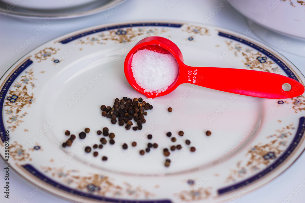 Salt and pepper in a white plate Salt and pepper in a white plate