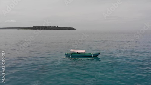 Drone orbiting a small fishing boat close to Pulau Mincau Island near Simeulue Island, located off the coast of North Sumatra in Indonesia. photo