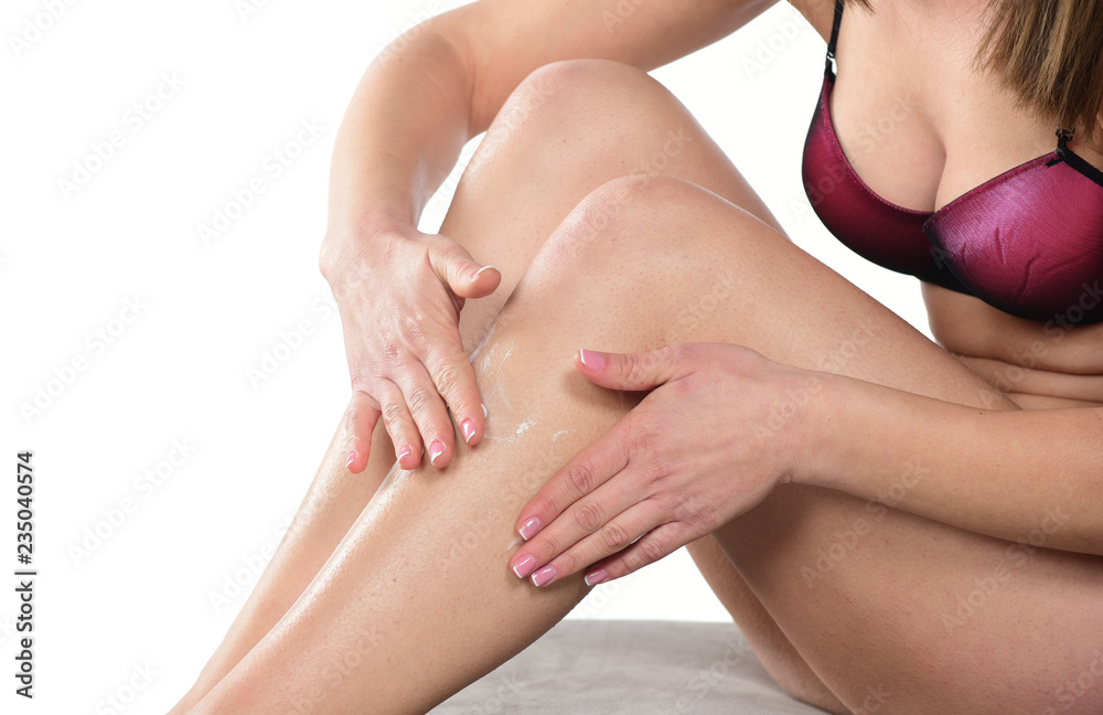Fototapeta premium beautiful female model applying body lotion on her body