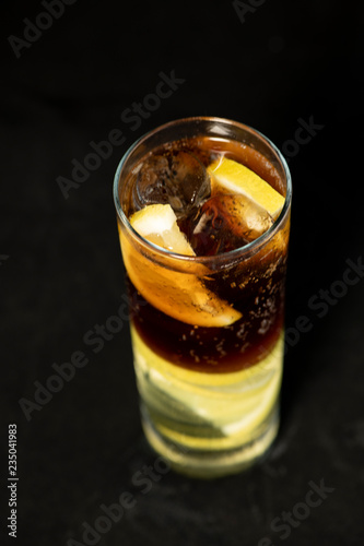 Cuba Libre cocktail with rum, coke and lime juice with lime wedge and full of ices