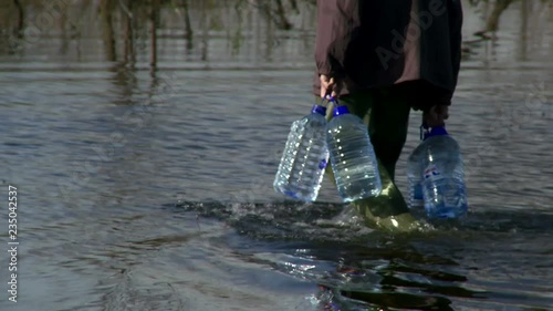 Man walk through the water and carrying water supplies in flooded area