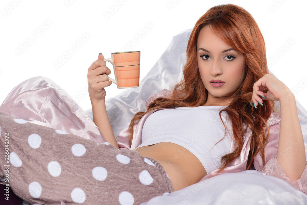 beautiful red headed women drinking coffee-tea and holding cup isolated on white
