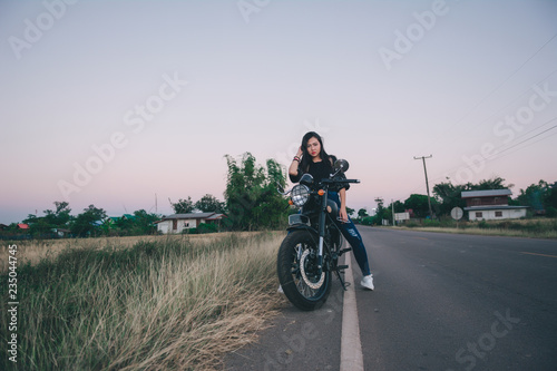 Young sexy woman on a motorcycle in nature on the sunset.Travel Concept.