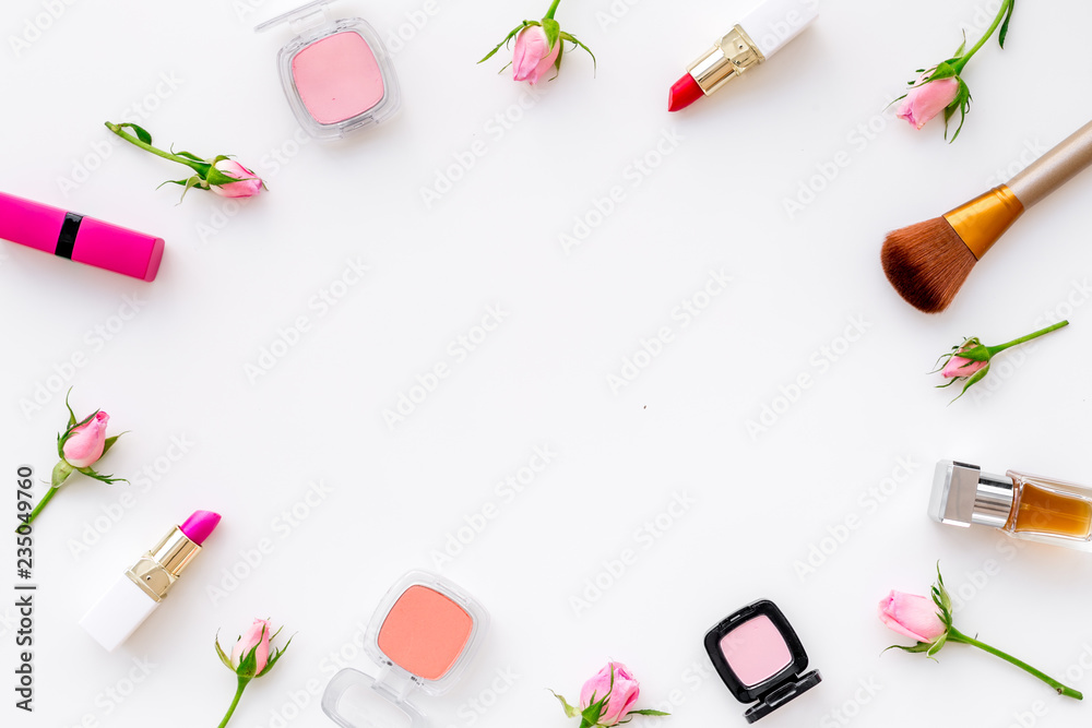 Rose, pink decorative cosmetics frame. Lipstick, bulk, eyeshadow and small rose flowers on white background top view copy space Rose, pink decorative cosmetics frame. Lipstick, bulk, eyeshadow and small rose flowers on white background top view copy space
