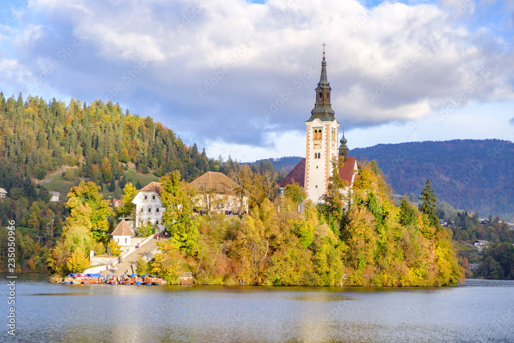 Scenic view of small island with church of the Assumption of Maria in center of lake Bled - the most popular hiking spot in Slovenia. Beautiful photo of world pilgrimage center.
