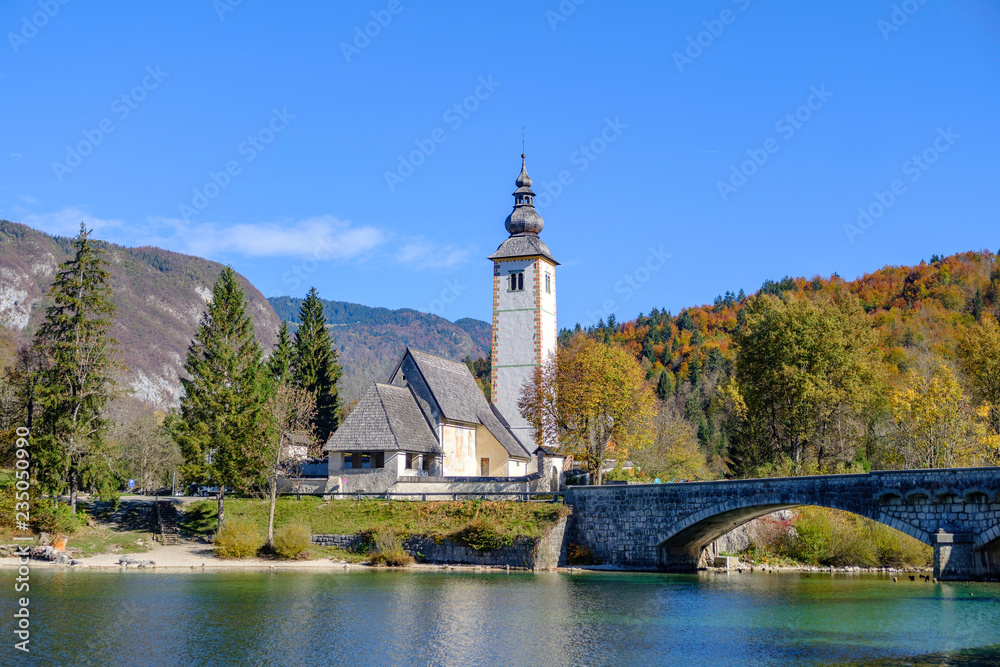Scenic view of old church of Saint Janez Krstnik on bank of lake Bohinj (Bohinjsko jezero) in Slovenia