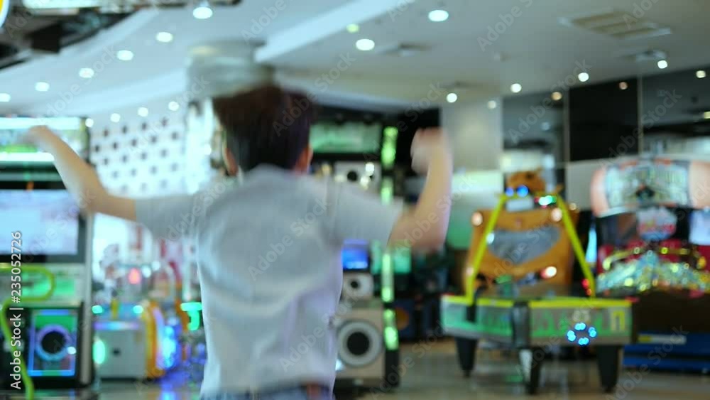 Children happy to play arcade game in toy land - blur background fun play land in the indoor arcade game city recreation Children happy to play arcade game in toy land - blur background fun play land in the indoor arcade game city recreation