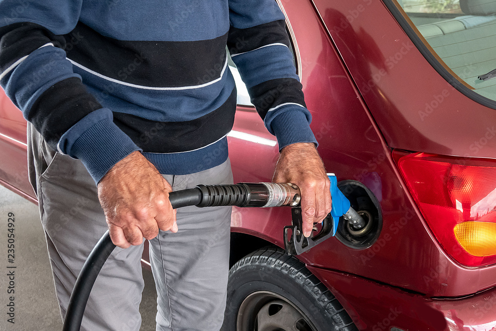 Human hands in the process of pouring gasoline at a gas station Human hands in the process of pouring gasoline at a gas station