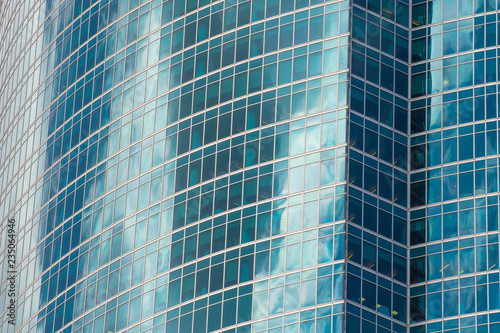 Abstract architecture of a modern building turquoise colored glass facade.