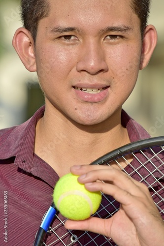 Smiling Athlete Filipino Male Tennis Player With Tennis Racket © dtiberio