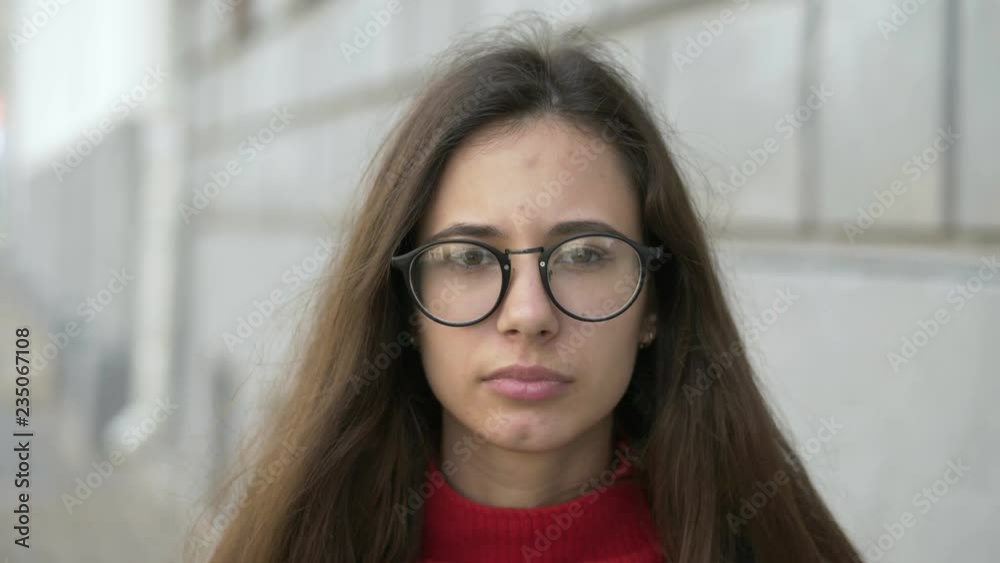 Slow motion portrait of beautiful trendy young european woman looking at camera running hand through hair enjoying urban city lifestyle. Real people concept. Slow motion portrait of beautiful trendy young european woman looking at camera running hand through hair enjoying urban city lifestyle. Real people concept.
