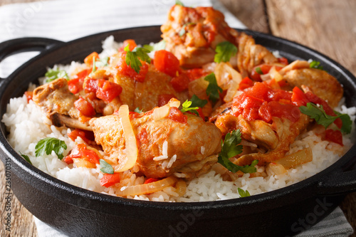 Haitian Chicken Recipe is a one pot of chicken, tomatoes, wine, spices, and rice close-up. horizontal