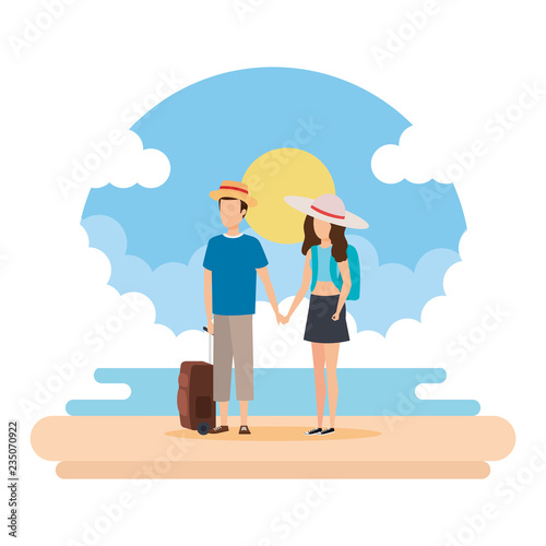 young couple with suitcase on the beach