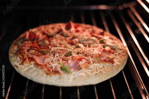 Pizza with ham and cheese in the electric oven