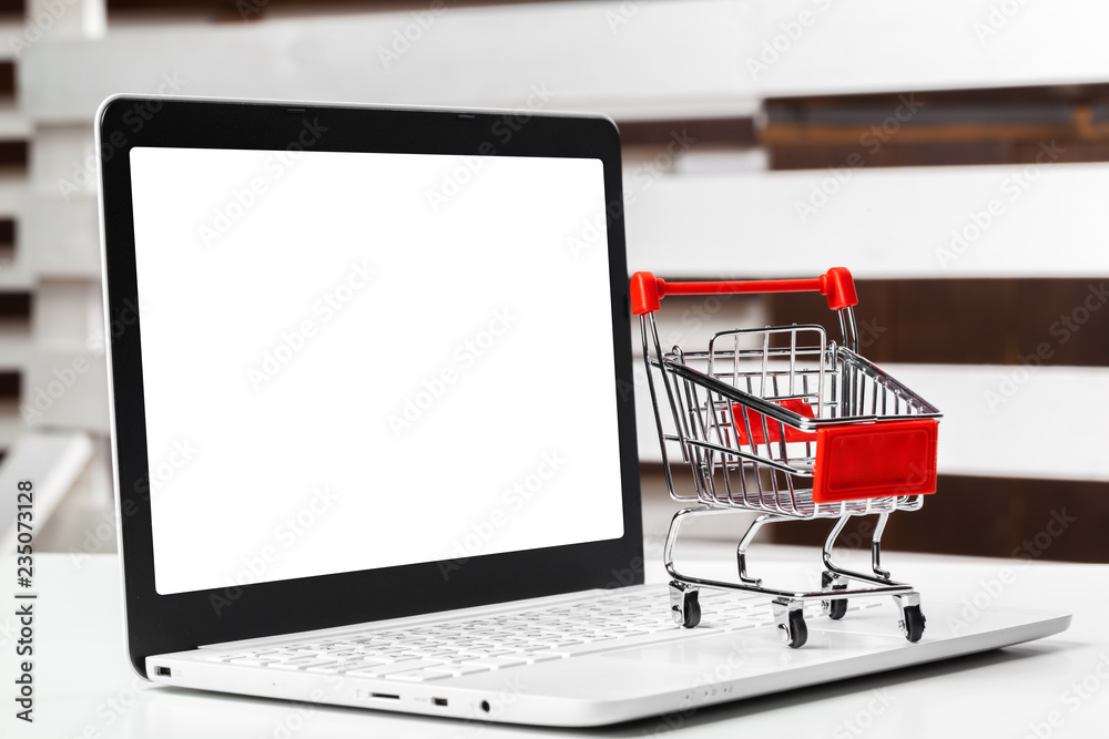 shopping online concept. small toy trolley and gadgets on the table