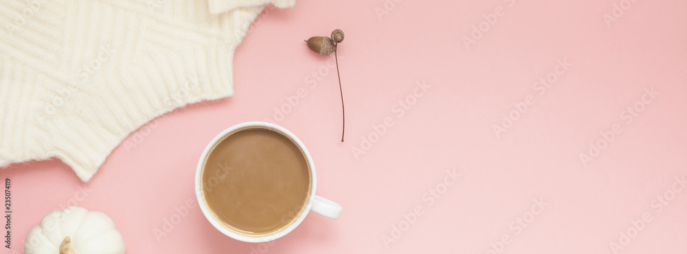 Cup of coffee and white sweater on pink background