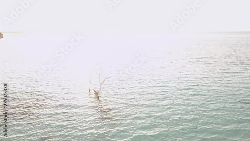 Panorama view on a tropical island in Maldives. Hammock in the blue water, white send beach and watervillas during a burning sunset. photo