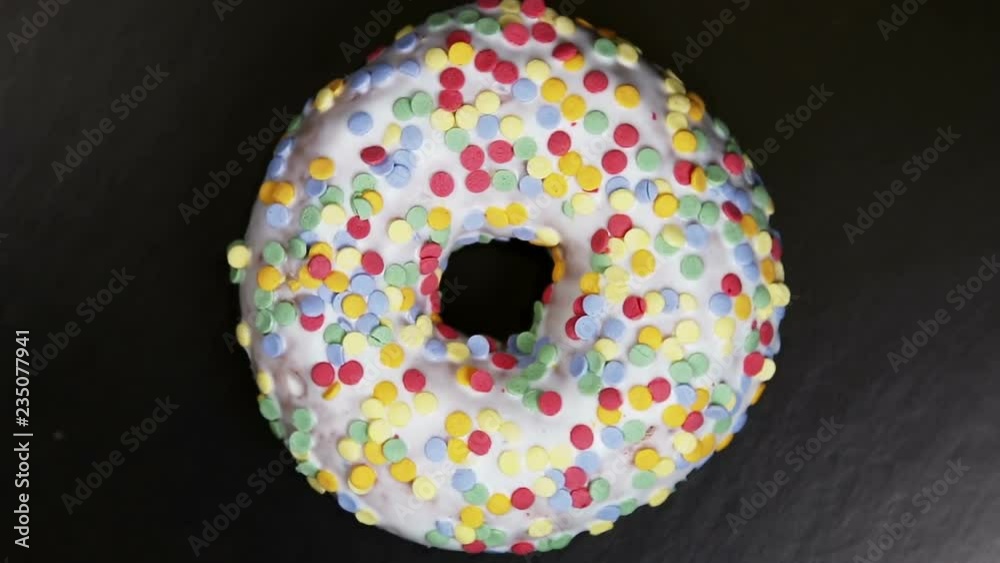 donut with different fillings and icing on black background. Rotation video