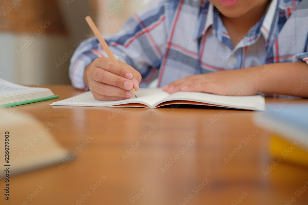 little asian kid boy schoolboy writing drawing on notebook. child children doing homework. little asian kid boy schoolboy writing drawing on notebook. child children doing homework.