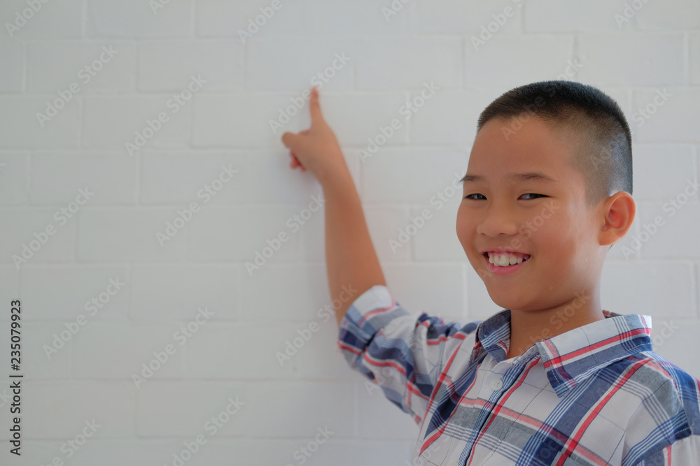 little asian kid boy child children schoolboy smiling & pointing up little asian kid boy child children schoolboy smiling & pointing up
