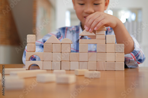 little asian kid boy child children schoolboy playing wood block toy. learning education concept