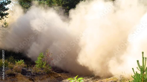 A rally car speeding through a dusty track leaving a cloud of dust.