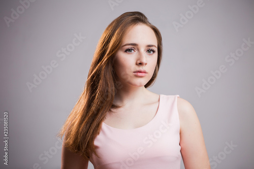 Portrait of a sad woman on gray background