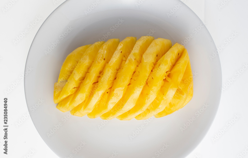 peeled pineapple on white plate peeled pineapple on white plate