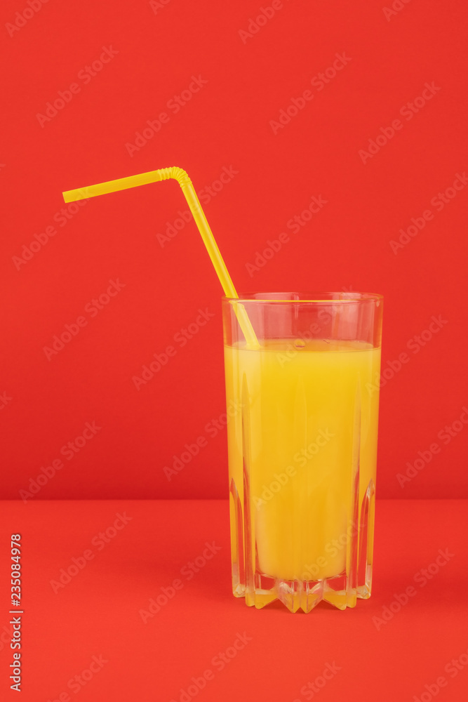 Orange cocktail drink on red background. Image of citrus juice glass at bright minimalistic environment. Orange cocktail drink on red background. Image of citrus juice glass at bright minimalistic environment.