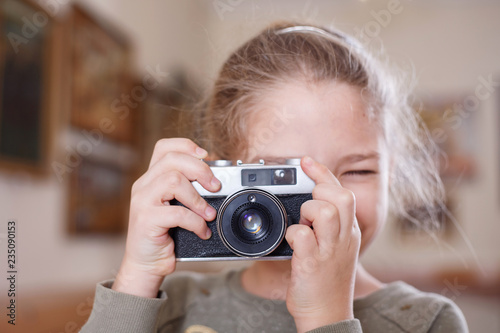 Girl with a retro camera makes a photo.