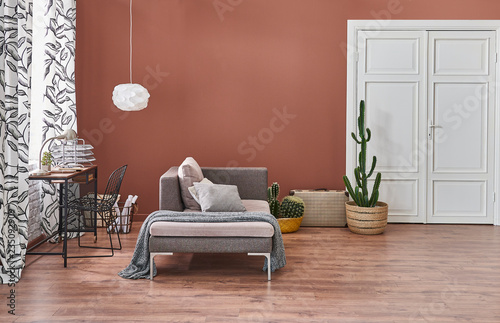 Modern living room brown background wooden desk and grey sofa.