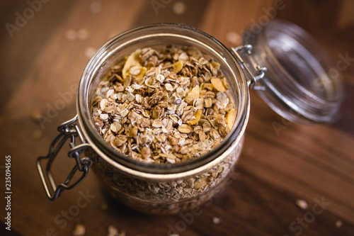 Glass jar with various seeds, oats and cereal.