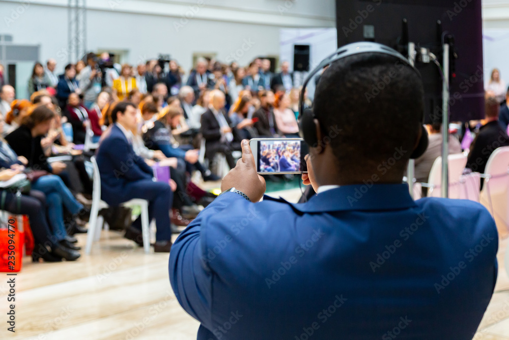 man taking photo on smartphone at a meeting man taking photo on smartphone at a meeting