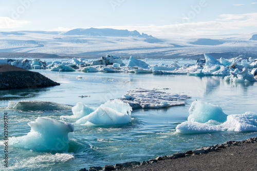 Fototapeta Naklejka Na Ścianę i Meble -  Gletschersee Jökulsarlon auf Island, von Gletscher abgebrochene Eisstücke schwimmen in der Mittagsonne auf der Gletscherlagune