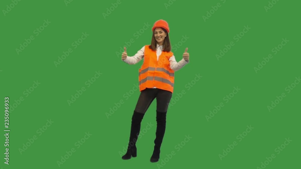 young woman in the construction helmet shows two thumb on green screen young woman in the construction helmet shows two thumb on green screen