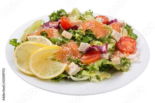 vegetable salad with tofu and salmon, lettuce and cherry tomatoes, decorated with a slice of lemon, on a plate, on a white background, isolate