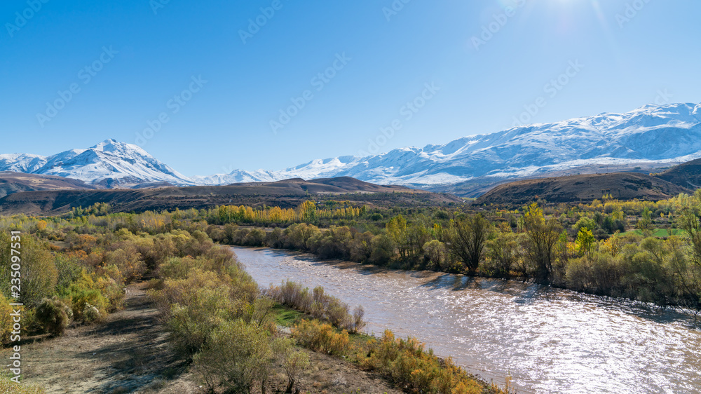 Panoramic view of a valley with snow capped mountains and River Euphrates near Erzincan, Turkey