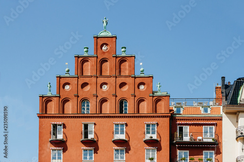 Old tiled roofs in district Kungsholmen in Stockholm, Sweden. Side view. Bronze green statues on the tops. Sunny day. Norr Malarstrand street architecture. © Т Т