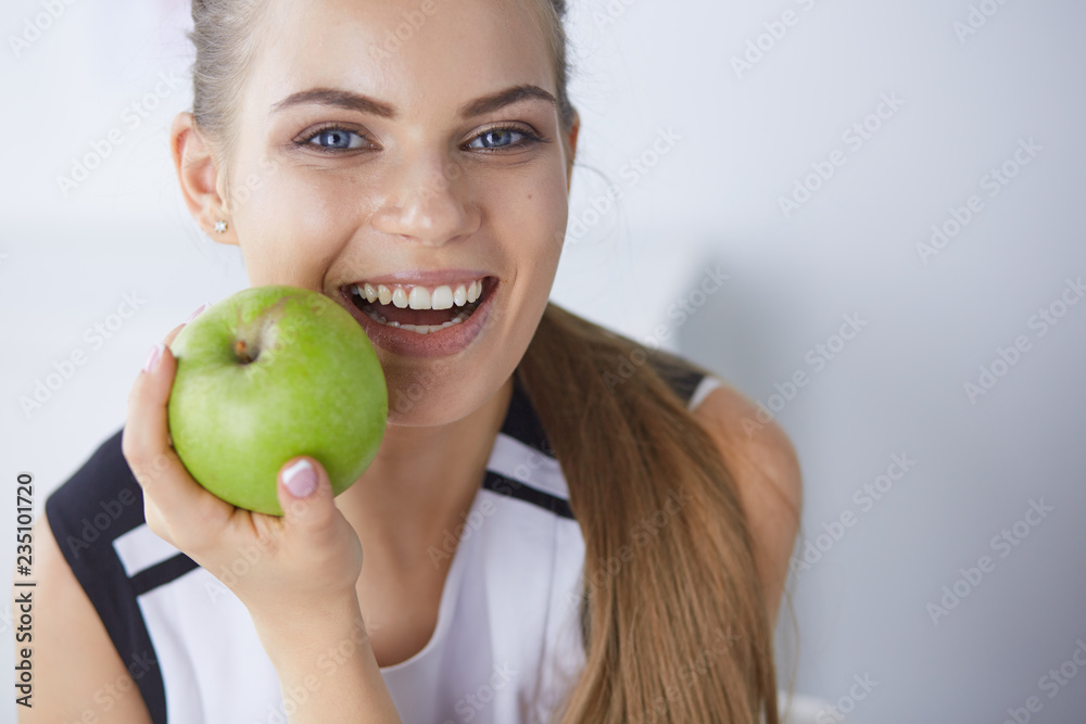 Young beautiful smiling girl with a green apple in hands Young beautiful smiling girl with a green apple in hands
