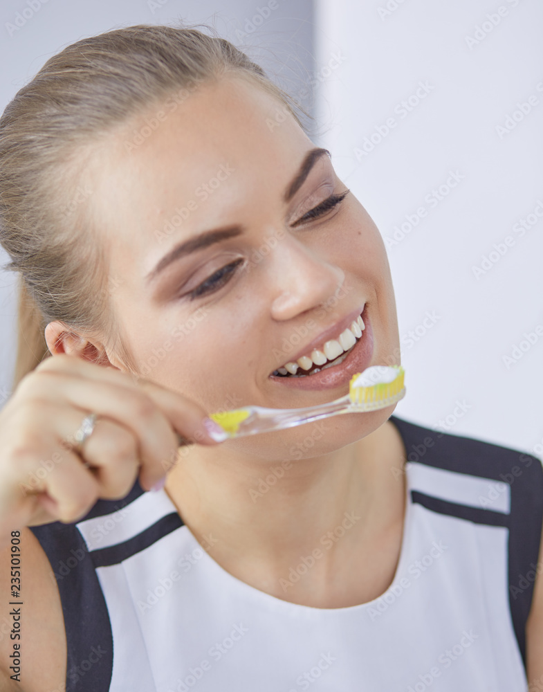 Smiling young woman with healthy teeth brushing her teeth Smiling young woman with healthy teeth brushing her teeth