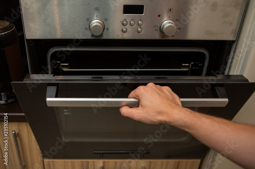 Photo of oven and human hand