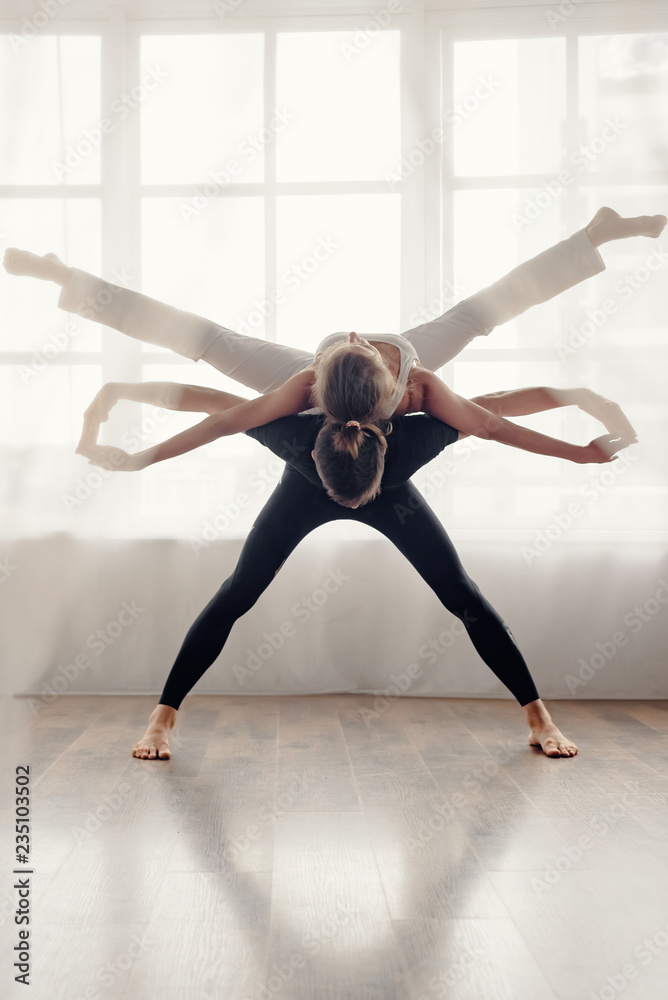 Obraz premium Beautiful sporty pair practicing yoga together at home
