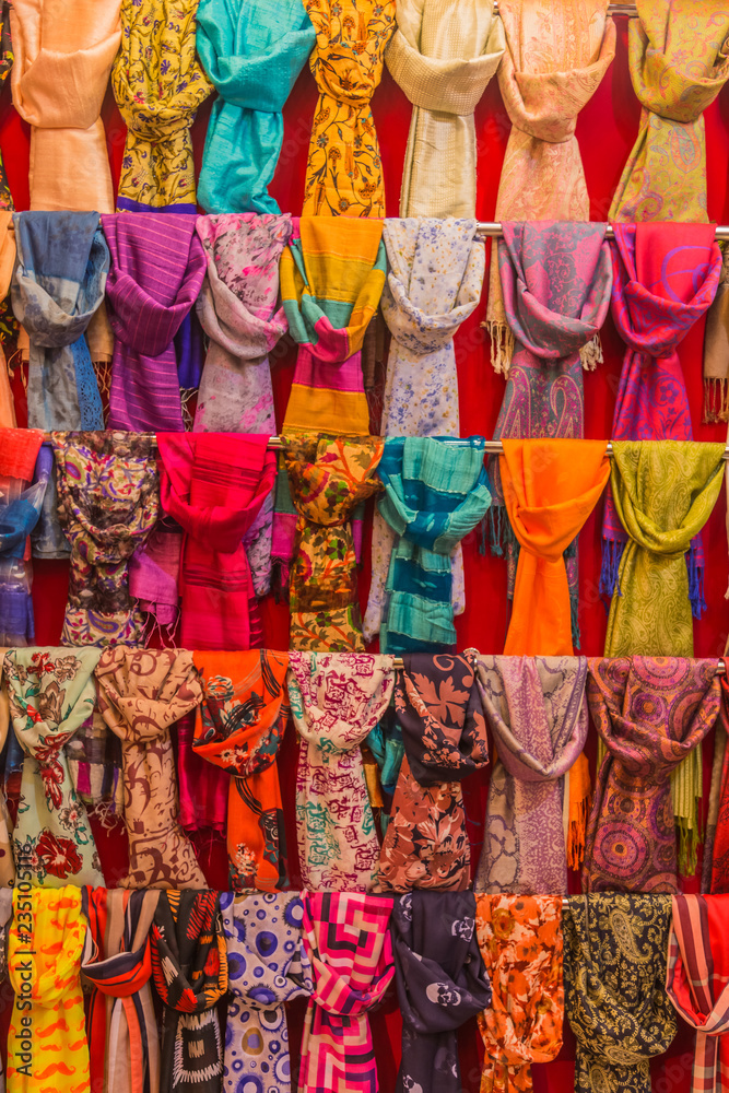 Colorful scarfs on display on racks in a bazaar.