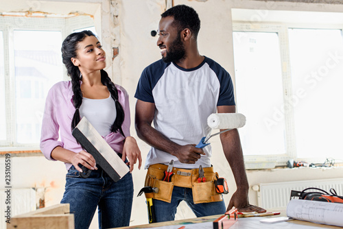 attractive young couple making renovation of apartments