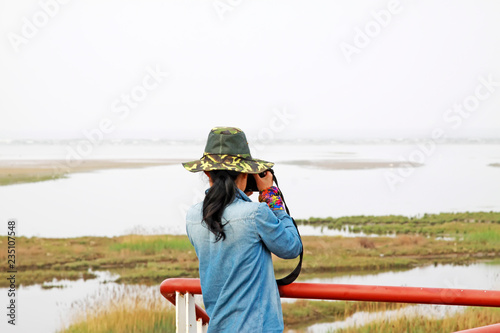 A female photographer was photographing in a wetland park, china © zhang yongxin