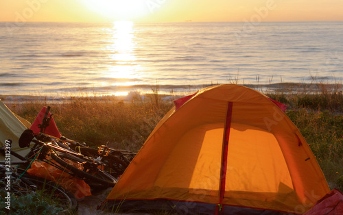 Tourist camping on the sand by the sea. Yellow tent on the sea sand. Tent on the beach, Baltic coast.
