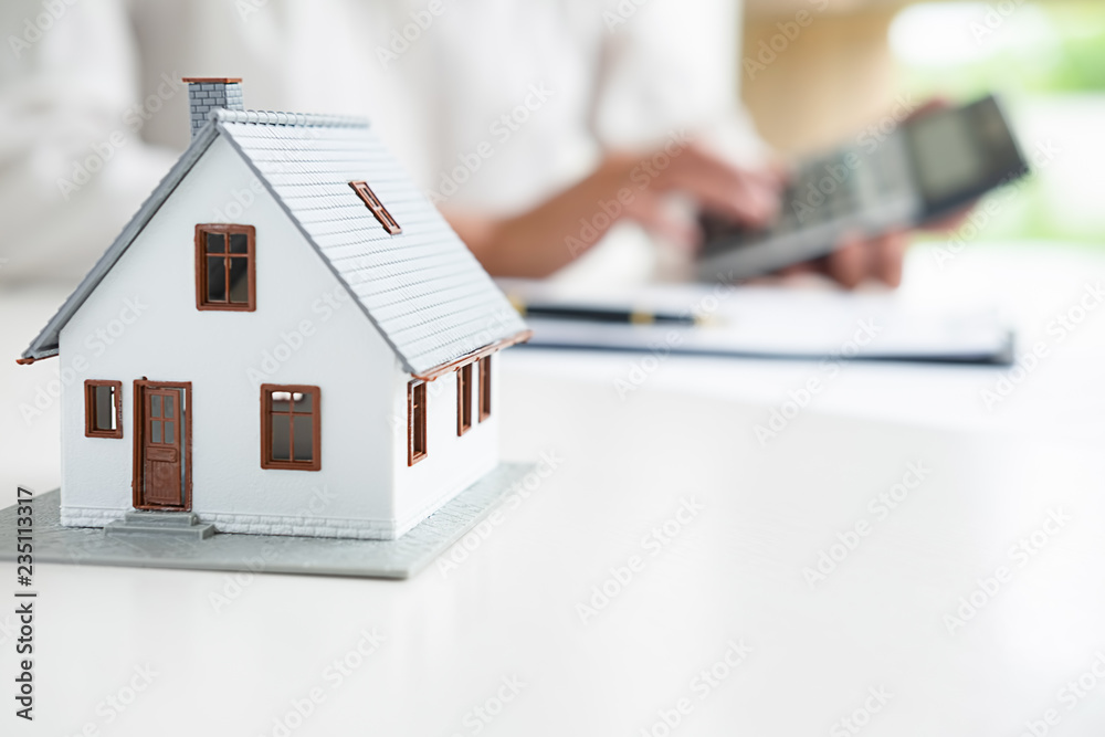 House model with real estate agent and customer discussing for contract to buy house, insurance or loan real estate background. House model with real estate agent and customer discussing for contract to buy house, insurance or loan real estate background.