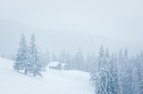 Dreamy winter scene with a mountain house in snow