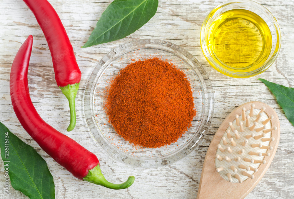 Dry chili pepper powder, olive oil and fresh red chili peppers for
